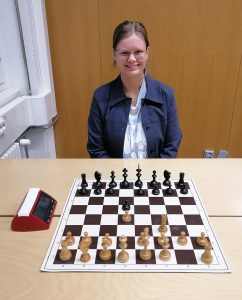 Shakkikilpailujen voittaja Sandra Carlsson edessään shakkilauta.