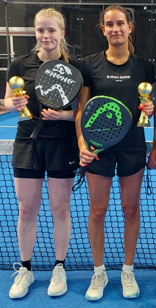 Emsa-joukkue ryhmäkuvassa. Joukkueen jäsenet pitelevät padel-mailoja ja pokaaleja.