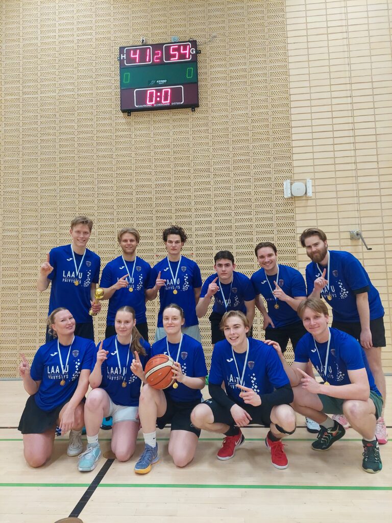 Functio Laesa -joukkue ryhmäkuvassa liikuntasalissa. Joukkueen jäsenillä on mitallit kaulassa.