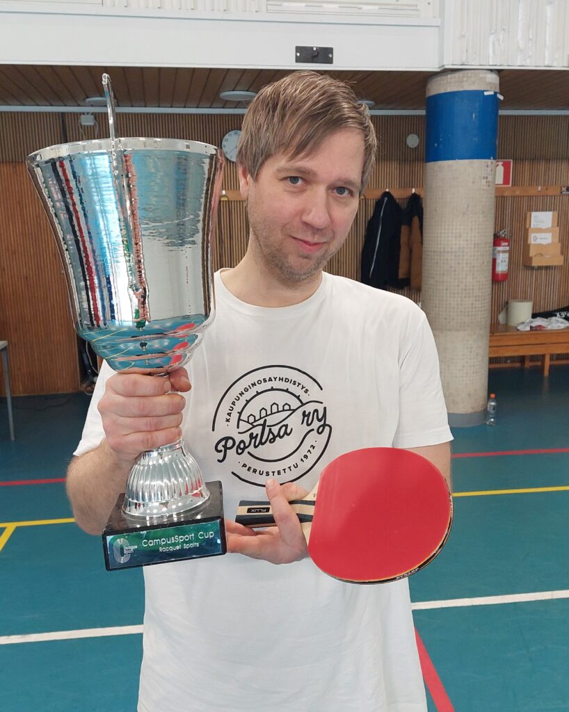 CampusSport Cupin mailapelien voittaja pitelee pokaalia Iskerin liikuntasalissa.